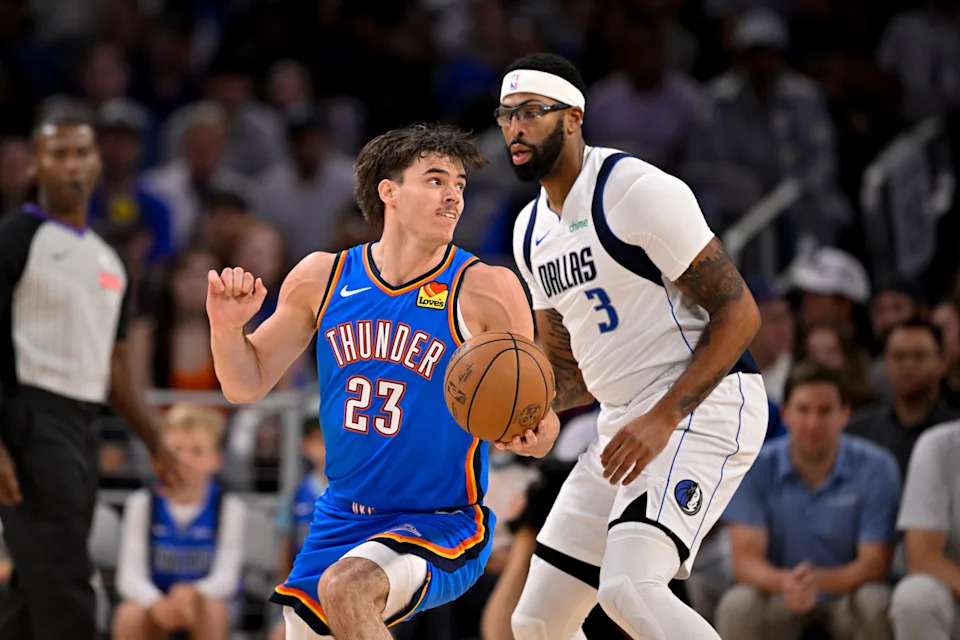 Oct 6, 2025; Fort Worth, Texas, USA; Oklahoma City Thunder guard Brooks Barnhizer (23) looks to move the ball past Dallas Mavericks forward/center Anthony Davis (3) during the first quarter at Dickie's Arena. Mandatory Credit: Jerome Miron-Imagn Images