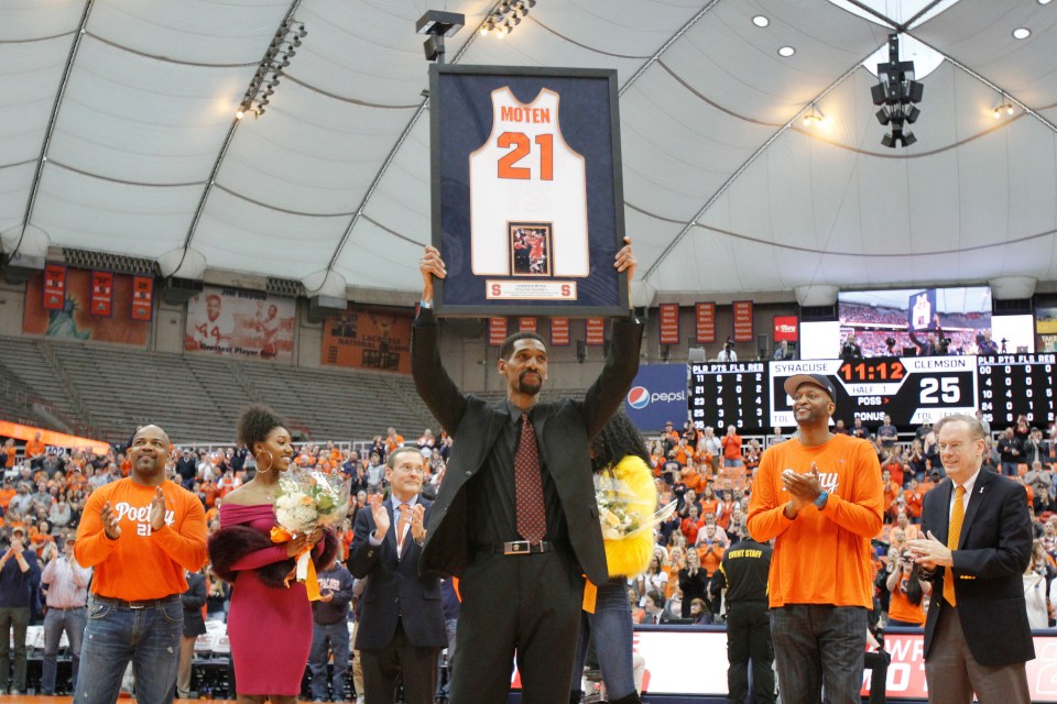 Lawrence Moten holding up his retired Syracuse jersey number 21 during a ceremony.
