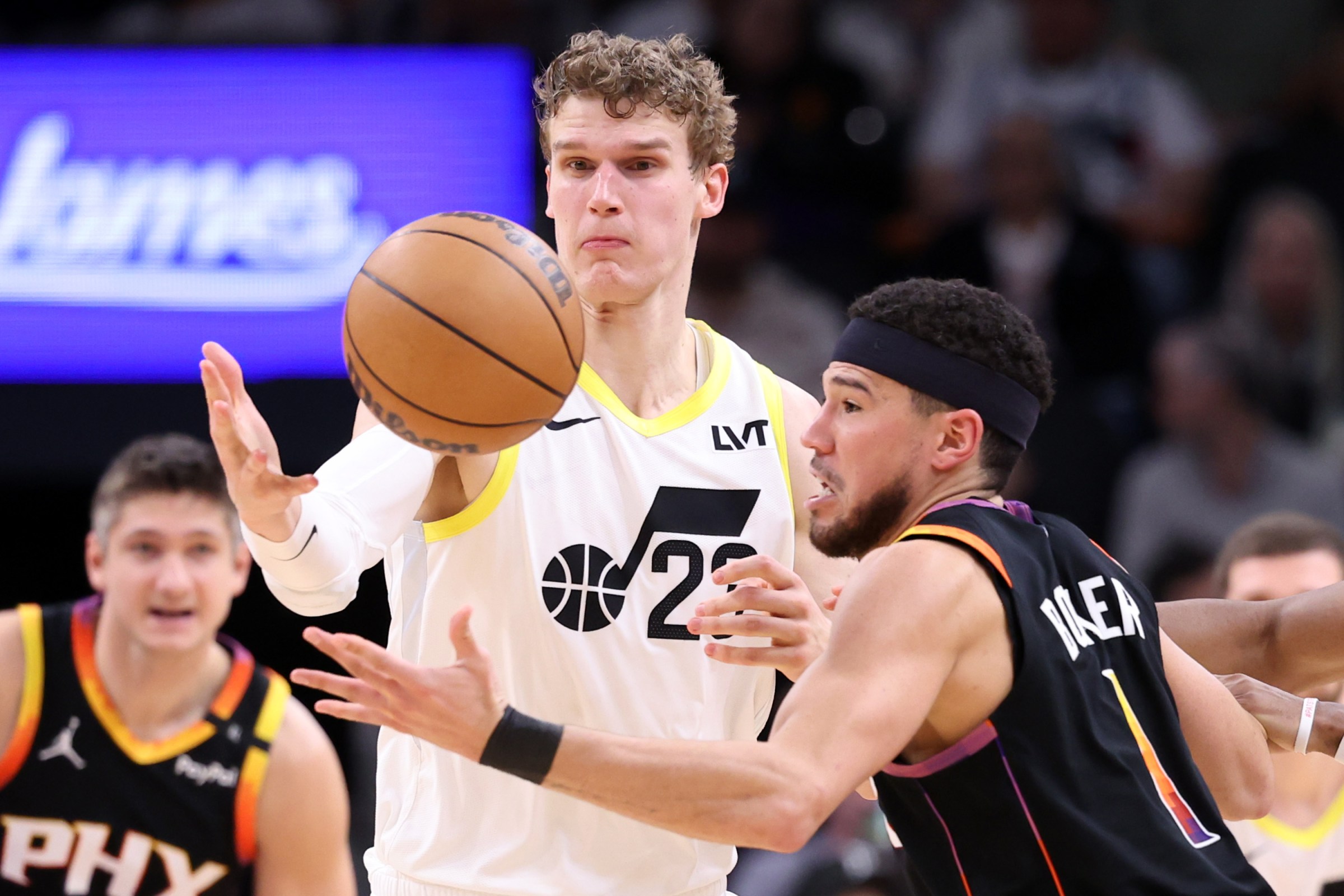 PHOENIX, ARIZONA - FEBRUARY 07: Lauri Markkanen #23 of the Utah Jazz attempts to steal the ball from Devin Booker #1 of the Phoenix Suns during the second half at Footprint Center on February 07, 2025 in Phoenix, Arizona. NOTE TO USER: User expressly acknowledges and agrees that, by downloading and or using this photograph, User is consenting to the terms and conditions of the Getty Images License Agreement. (Photo by Chris Coduto/Getty Images)