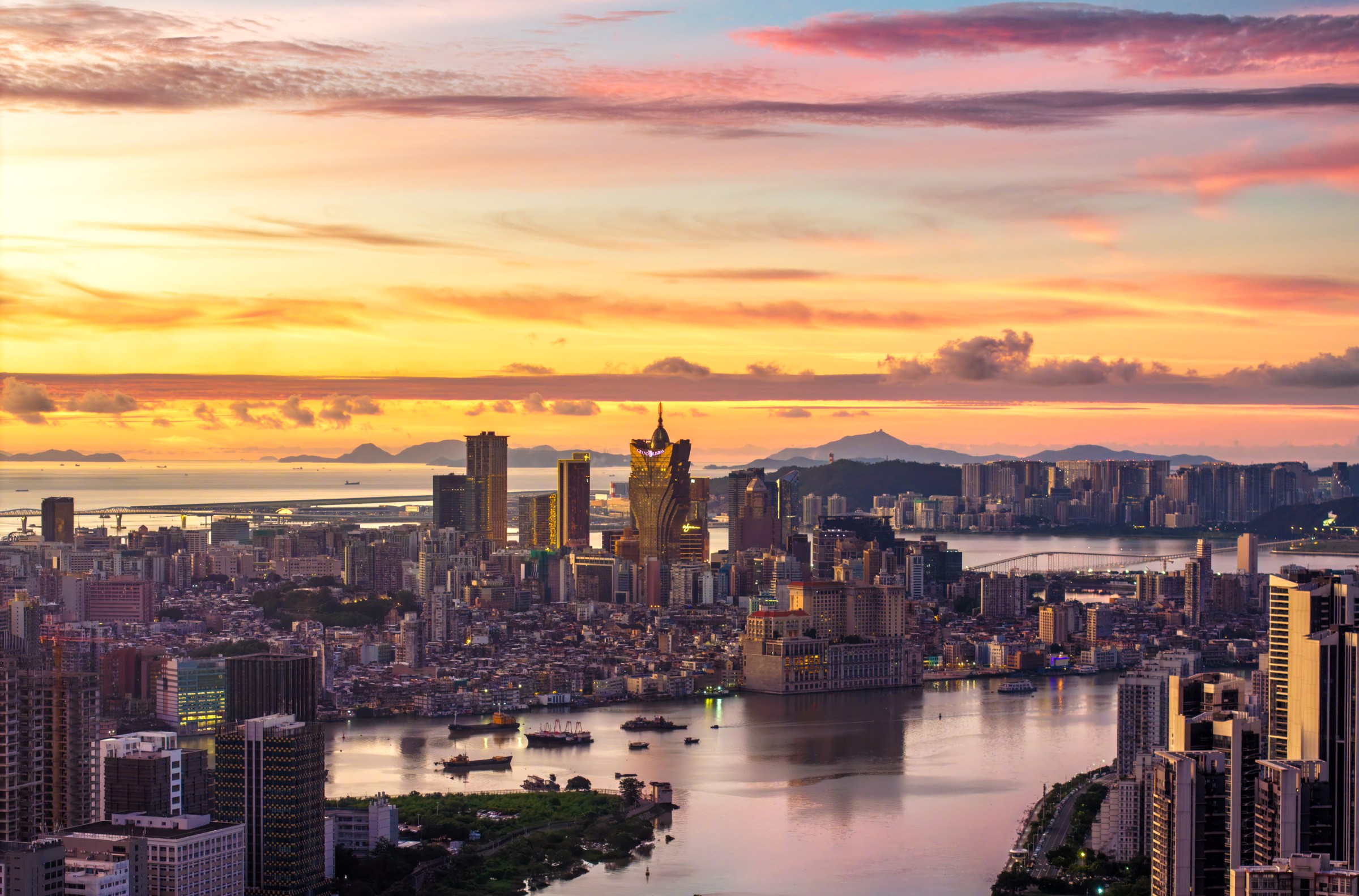 MACAO, CHINA - AUGUST 22: The morning glow shines over the city skyline at sunrise on August 22, 2025 in Macao, China. (Photo by Chen Shuoming/VCG via Getty Images)