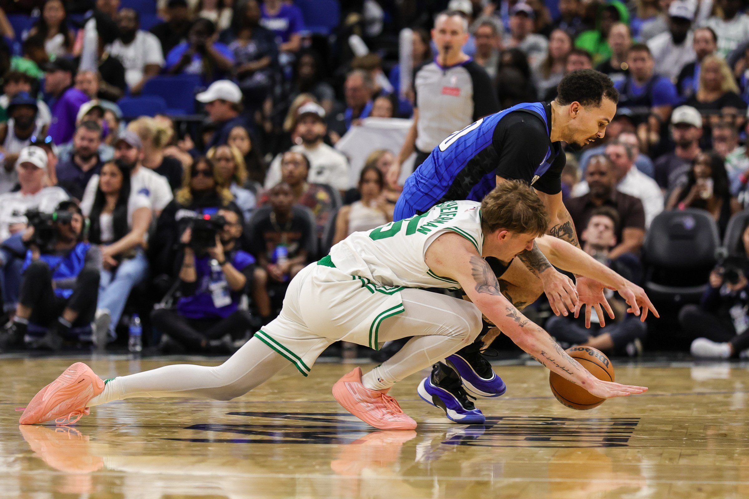 Apr 9, 2025; Orlando, Florida, USA; Orlando Magic guard Cole Anthony (50) and Boston Celtics forward Baylor Scheierman (55) chase a loose ball during the second half at Kia Center. Mandatory Credit: Mike Watters-Imagn Images