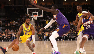 RJ Davis #55 of the Los Angeles Lakers controls the ball as Khaman Maluach #10 of the Phoenix Suns ...