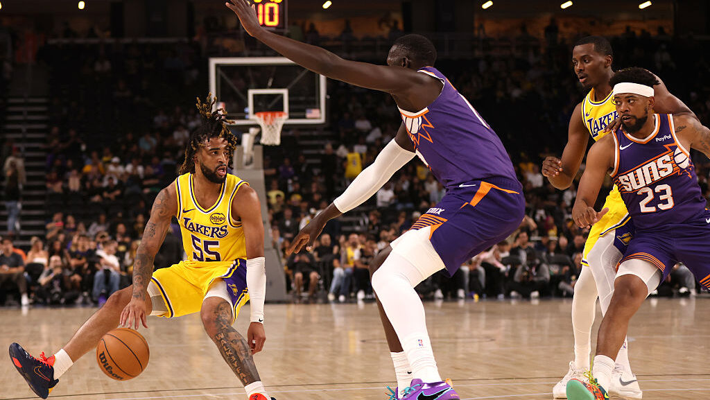 RJ Davis #55 of the Los Angeles Lakers controls the ball as Khaman Maluach #10 of the Phoenix Suns ...