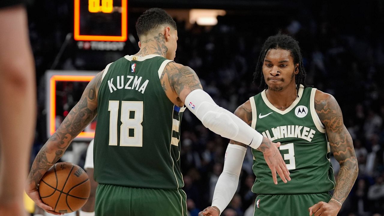Milwaukee Bucks forward Kyle Kuzma (18) and guard Kevin Porter Jr. (3) celebrate as time expires during an NBA basketball game against the Minnesota Timberwolves, Wednesday, Feb. 12, 2025, in Minneapolis.