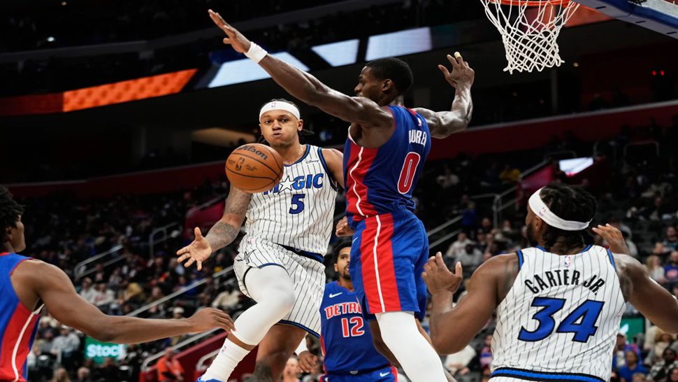 Orlando Magic forward Paolo Banchero (5) passes to center Wendell Carter Jr. (34) while under pressure from Detroit Pistons center Jalen Duren (0) during the first half of an NBA basketball game Wednesday, Oct. 29, 2025, in Detroit. (AP Photo/Ryan Sun)