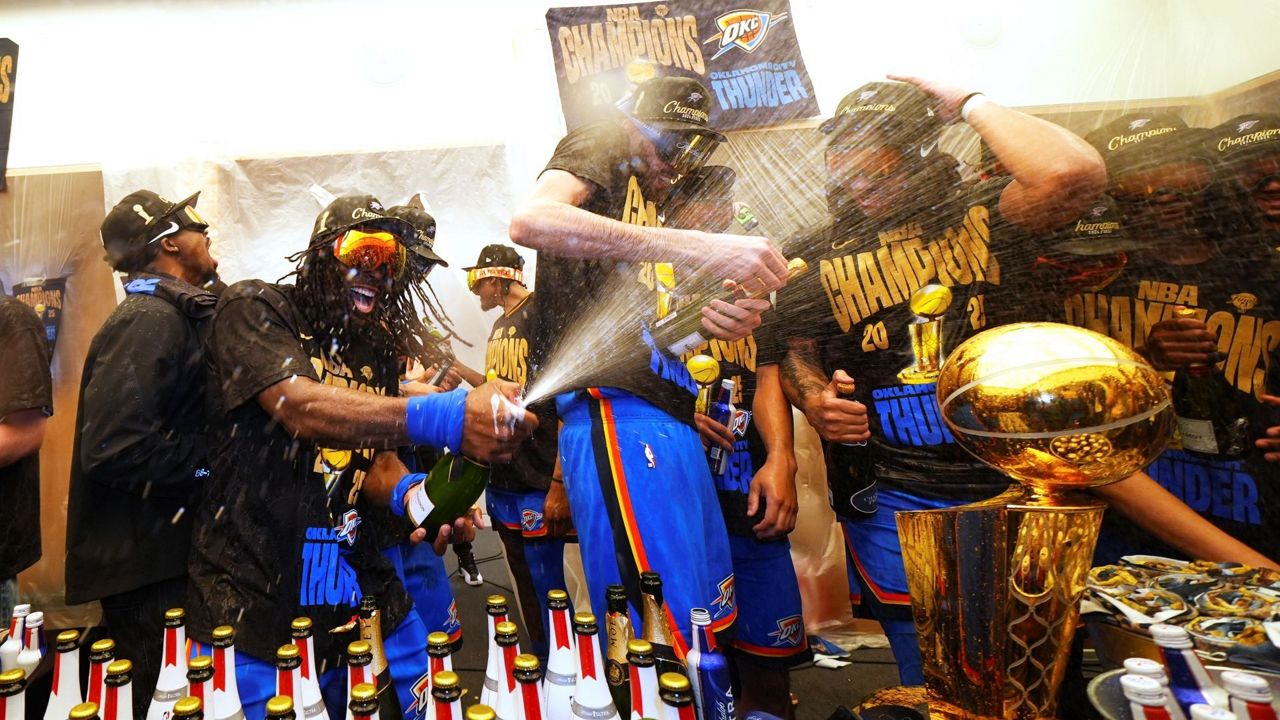 Oklahoma City Thunder guard Luguentz Dort, left, celebrates with teammates in the locker room after winning the NBA basketball championship with a Game 7 victory against the Indiana Pacers Sunday, June 22, 2025, in Oklahoma City. (AP Photo/Julio Cortez)