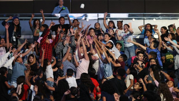 Students reach for player-thrown t-shirts during the annual Pick, Read...