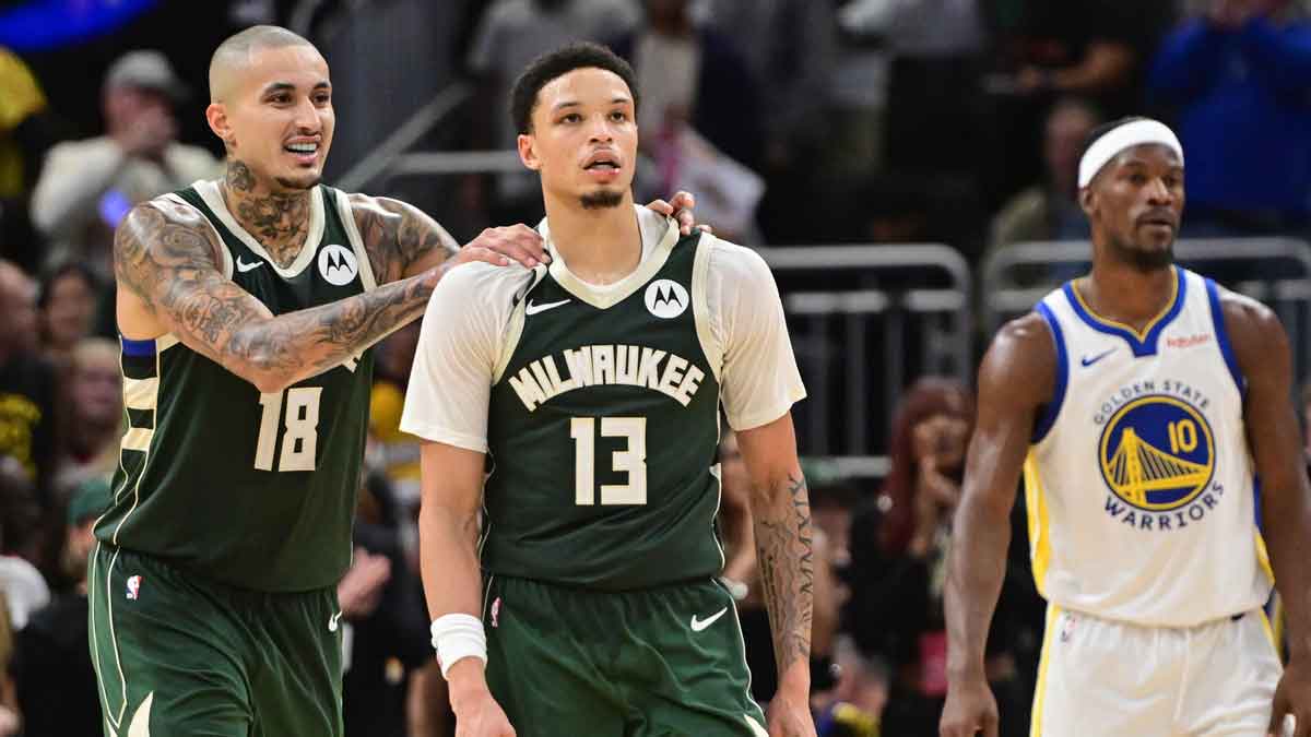 Milwaukee Bucks guard Ryan Rollins (13) celebrates with forward Kyle Kuzma (18) after beating the Golden State Warriors as Warriors forward Jimmy Butler (10) looks on at Fiserv Forum.
