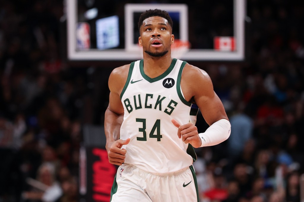 Giannis Antetokounmpo in a white Milwaukee Bucks jersey.