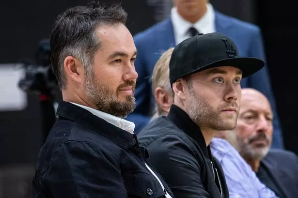 Joey and Jesse Buss watch from courtside