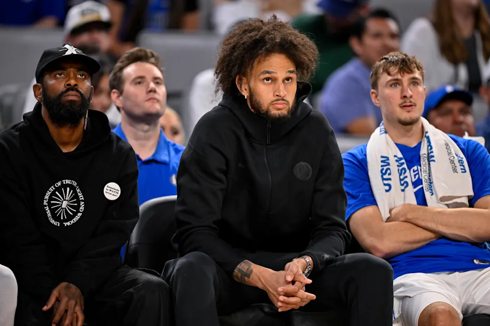 Dallas Mavericks guard Kyrie Irving (left) and center Dereck Lively II (center) and forward Cooper Flagg (right) look on during a game.Jerome Miron-Imagn Images