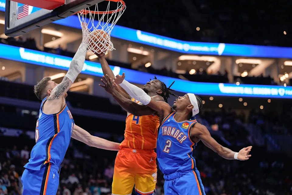Nov 15, 2025; Charlotte, North Carolina, USA; Charlotte Hornets guard Sion James (4) goes to the basket against Oklahoma City Thunder center Isaiah Hartenstein (55) and guard Shai Gilgeous-Alexander (2) during the first half at Spectrum Center. Mandatory Credit: Jim Dedmon-Imagn Images