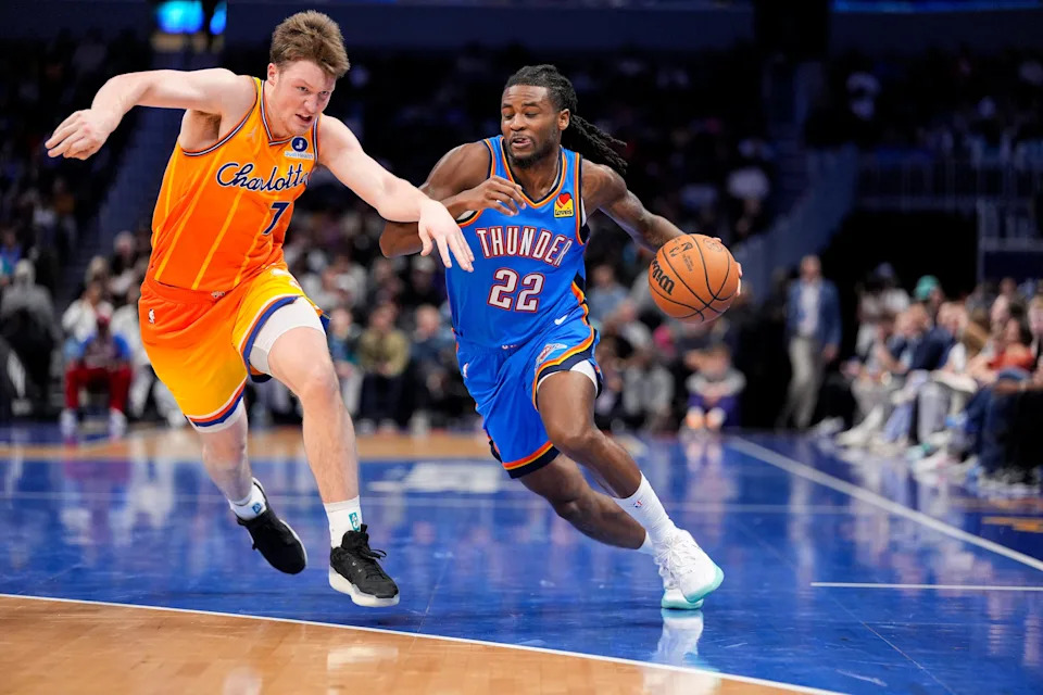 Nov 15, 2025; Charlotte, North Carolina, USA; Oklahoma City Thunder guard Cason Wallace (22) handles the ball against Charlotte Hornets guard Kon Knueppel (7) during the second half at Spectrum Center. Mandatory Credit: Jim Dedmon-Imagn Images