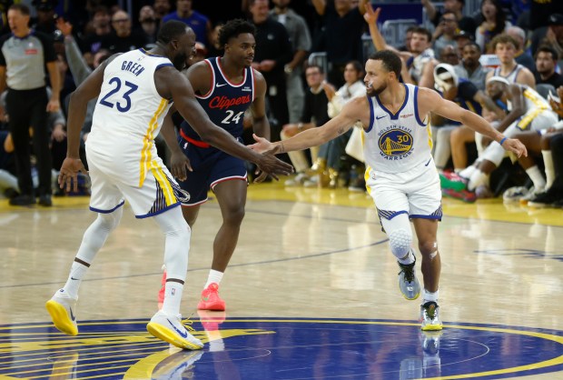 Golden State Warriors' Draymond Green (23) high-fives Golden State Warriors' Stephen Curry (30) after Curry made a 3-point basket against the Los Angeles Clippers in the third quarter at the Chase Center in San Francisco, Calif., on Tuesday, Oct. 28, 2025. (Nhat V. Meyer/Bay Area News Group)