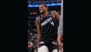 Phoenix Suns guard Jalen Green grabs his leg before leaving the court during the first half of an N...