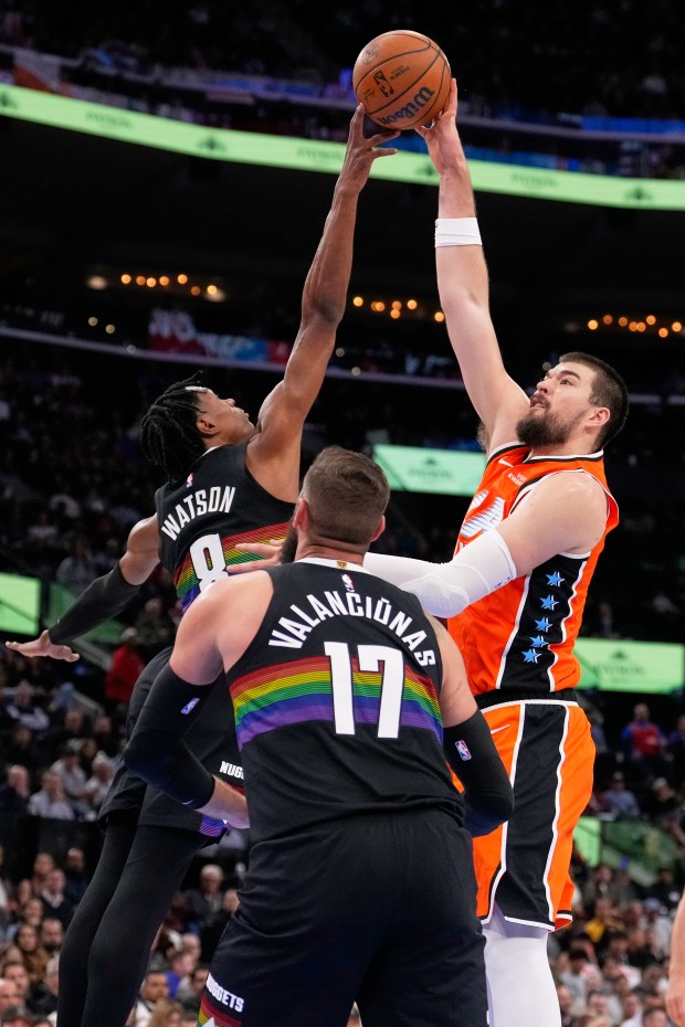 Clippers center Ivica Zubac, right, shoots as Denver Nuggets guard...