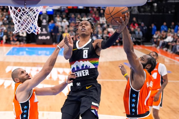 Denver Nuggets guard Peyton Watson, center, shoots as Clippers forward...