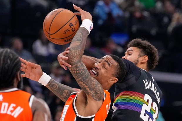 Clippers forward John Collins, center, grabs a pass as Denver...