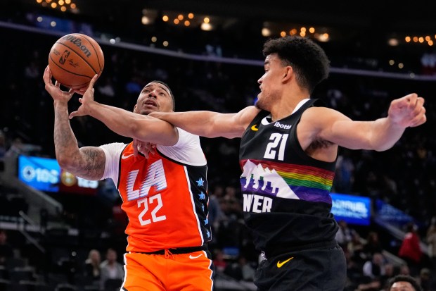Clippers guard Jordan Miller, left, shoots as Denver Nuggets forward...