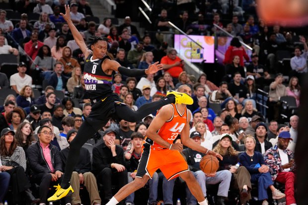 Clippers forward Nicolas Batum,, right, tries to shoot as Denver...