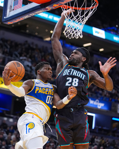 Indiana Pacers guard Bennedict Mathurin (00) makes a pass around Detroit Pistons forward Isaiah Stewart (28) during the second half of an NBA basketball game in Indianapolis, Monday, Nov. 24, 2025. (AP Photo/Michael Conroy)