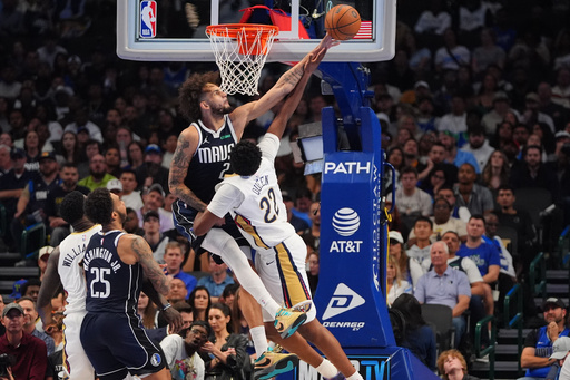 New Orleans Pelicans center Derik Queen (22) shot is blocked by Dallas Mavericks center Dereck Lively II (2) as Pelicans forward Zion Williamson (1) and Mavericks forward P.J. Washington (25) look on during the second half of an NBA Cup basketball game in Dallas, Friday, Nov. 21, 2025. (AP Photo/LM Otero)