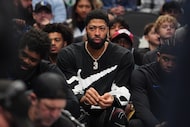 Injured Dallas Mavericks forward Anthony Davis, center, sits on the bench during the second...