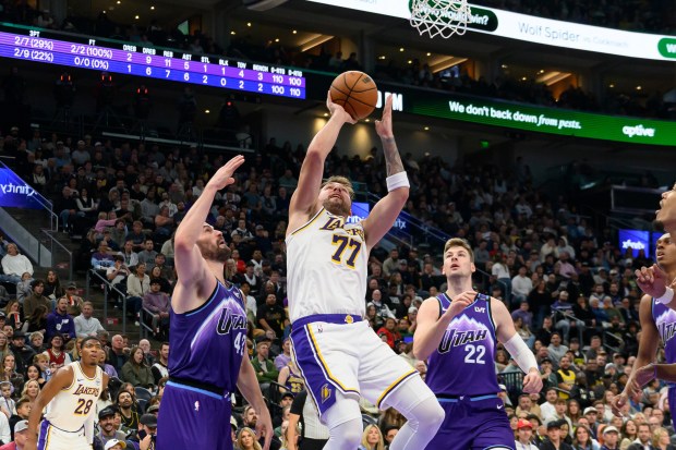 Lakers guard Luka Doncic (77) shoots the ball guarded by...