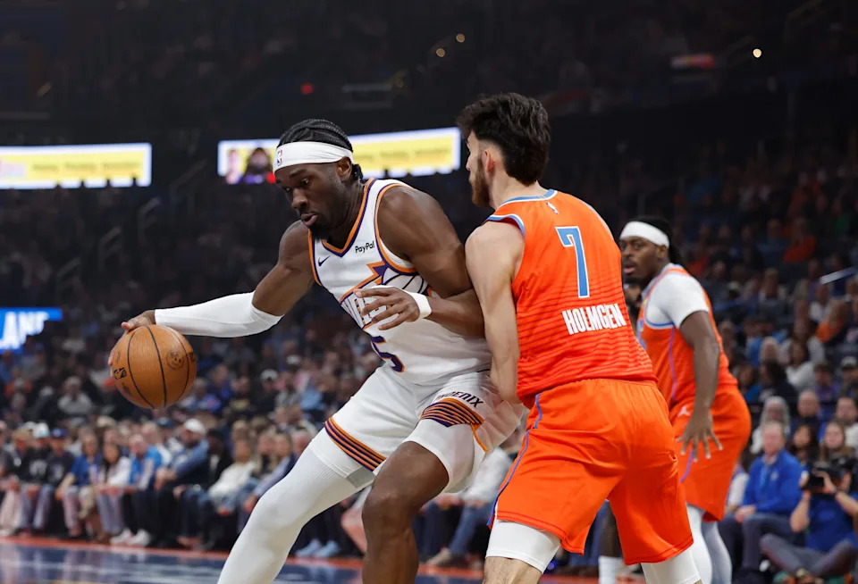 Nov 28, 2025; Oklahoma City, Oklahoma, USA; Phoenix Suns center Mark Williams (15) moves the ball against Oklahoma City Thunder center Chet Holmgren (7) during the first quarter at Paycom Center. Mandatory Credit: Alonzo Adams-Imagn Images
