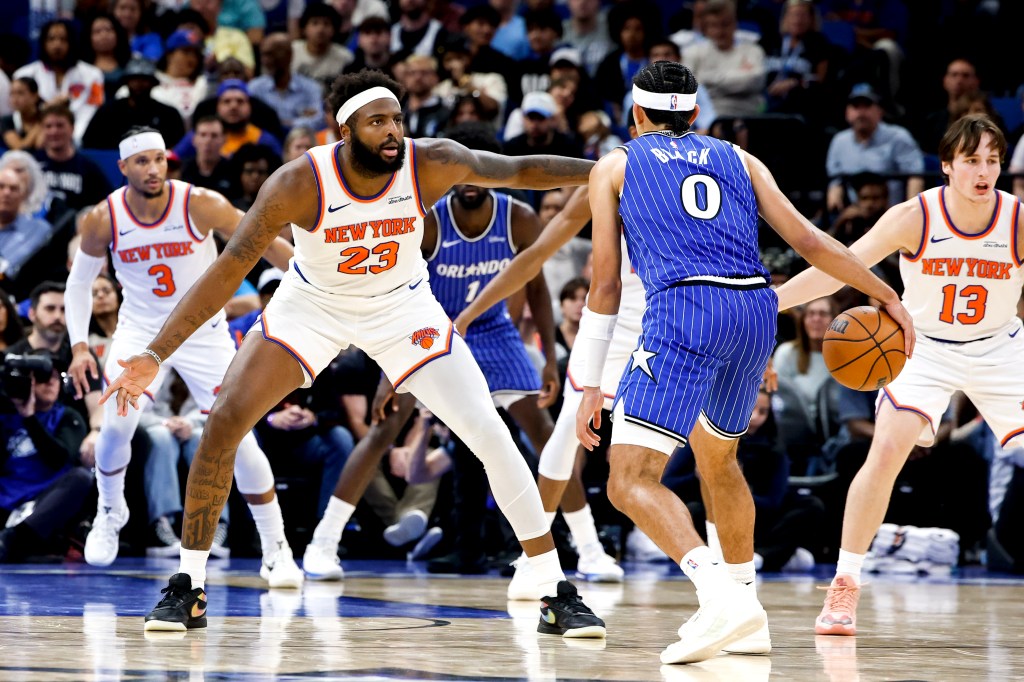 Mitchell Robinson #23 of the New York Knicks defends Anthony Black #0 of the Orlando Magic at mid-court