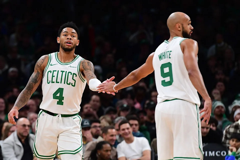 Nov 23, 2025; Boston, Massachusetts, USA; Boston Celtics guard Anfernee Simons (4) is congratulated by guard Derrick White (9) after a basket during the first half at TD Garden. Mandatory Credit: Bob DeChiara-Imagn Images