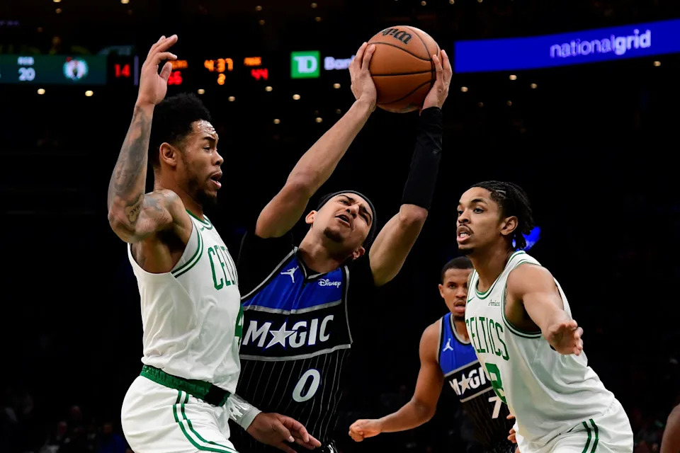 Nov 23, 2025; Boston, Massachusetts, USA; Orlando Magic guard Anthony Black (0) gets fouled by Boston Celtics guard Anfernee Simons (4) during the first half at TD Garden. Mandatory Credit: Bob DeChiara-Imagn Images