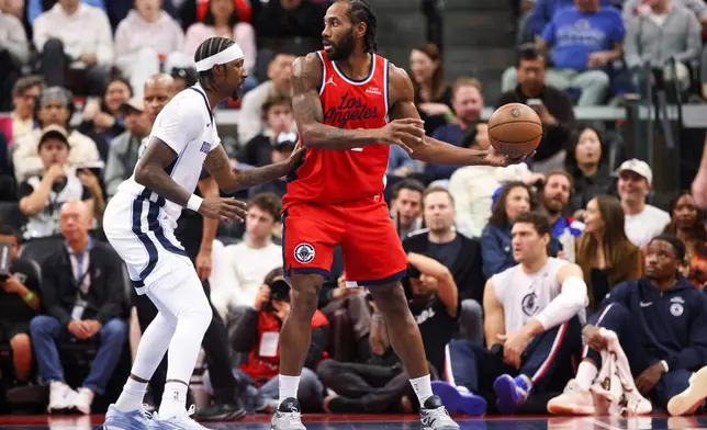 Los Angeles Clippers forward Kawhi Leonard, right, possesses the ball against Memphis Grizzlies guard Kentavious Caldwell-Pope, left, during the first half of an NBA Cup basketball game Friday, Nov. 28, 2025, in Inglewood, Calif. (AP Photo/Jessie Alcheh)