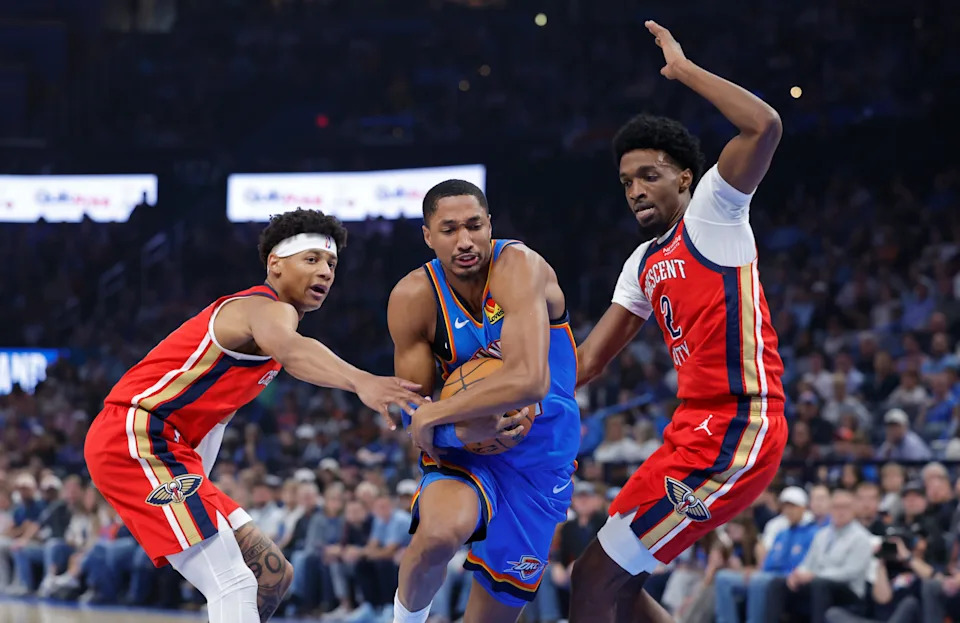 Nov 2, 2025; Oklahoma City, Oklahoma, USA; Oklahoma City Thunder guard Aaron Wiggins (21) drives between New Orleans Pelicans guard Jeremiah Fears (0) and forward Herbert Jones (2) during the first quarter at Paycom Center. Mandatory Credit: Alonzo Adams-Imagn Images