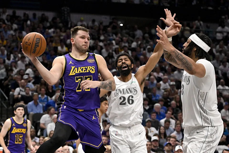 Los Angeles Lakers guard Luka Doncic (77) passes the ball by Dallas Mavericks guard Spencer Dinwiddie (26) and forward Anthony Davis (3) during the third quarter at the American Airlines Center in Dallas, Texas on April 9, 2025.