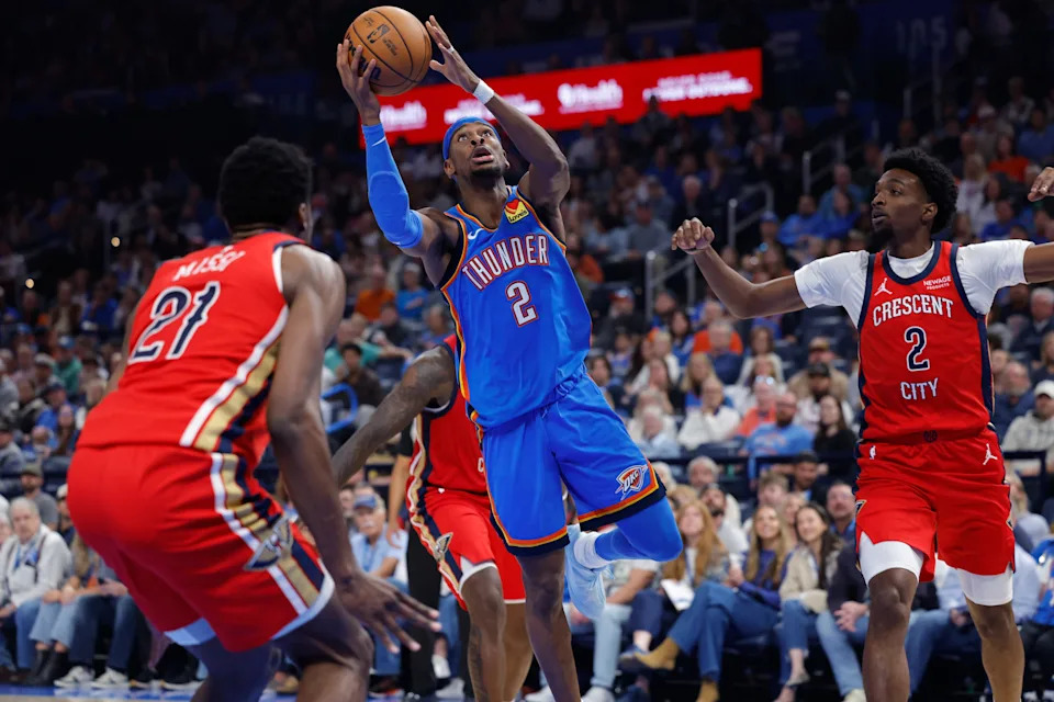 Nov 2, 2025; Oklahoma City, Oklahoma, USA; Oklahoma City Thunder guard Shai Gilgeous-Alexander (2) goes up for a basket between New Orleans Pelicans center Yves Missi (21) and forward Herbert Jones (2) during the second quarter at Paycom Center. Mandatory Credit: Alonzo Adams-Imagn Images