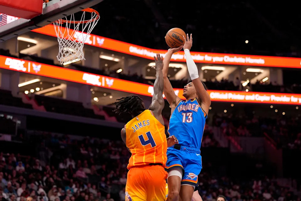 Nov 15, 2025; Charlotte, North Carolina, USA; Oklahoma City Thunder forward Ousmane Dieng (13) shoots over Charlotte Hornets guard Sion James (4) during the second half at Spectrum Center. Mandatory Credit: Jim Dedmon-Imagn Images