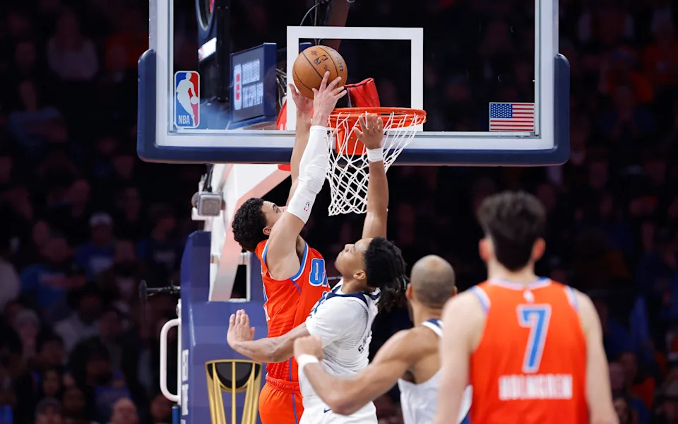 Nov 26, 2025; Oklahoma City, Oklahoma, USA; Oklahoma City Thunder guard Ajay Mitchell (25) dunks as Minnesota Timberwolves guard Terrence Shannon Jr. (1) defends during the second half at Paycom Center. Mandatory Credit: Alonzo Adams-Imagn Images