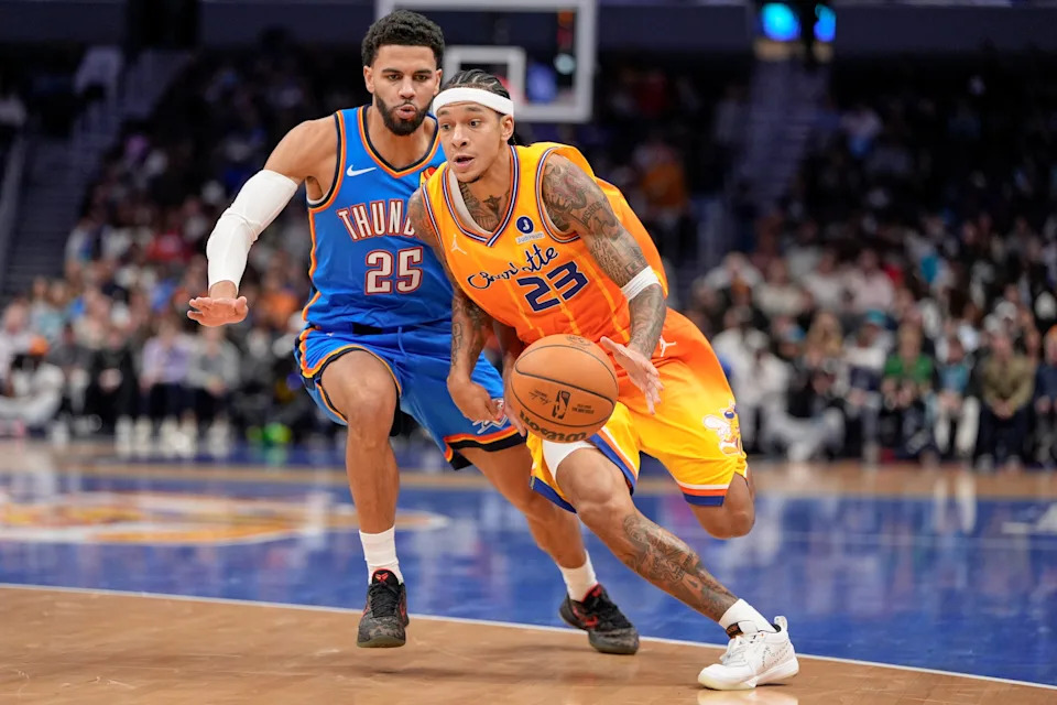 Nov 15, 2025; Charlotte, North Carolina, USA; Charlotte Hornets guard Tre Mann (23) drives to the basket against Oklahoma City Thunder guard Ajay Mitchell (25) during the first half at Spectrum Center. Mandatory Credit: Jim Dedmon-Imagn Images