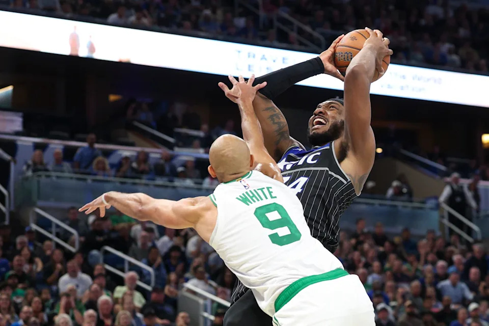 Nov 7, 2025; Orlando, Florida, USA; Orlando Magic center Wendell Carter Jr. (34) is fouled by Boston Celtics guard Derrick White (9) in the fourth quarter at Kia Center. Mandatory Credit: Nathan Ray Seebeck-Imagn Images