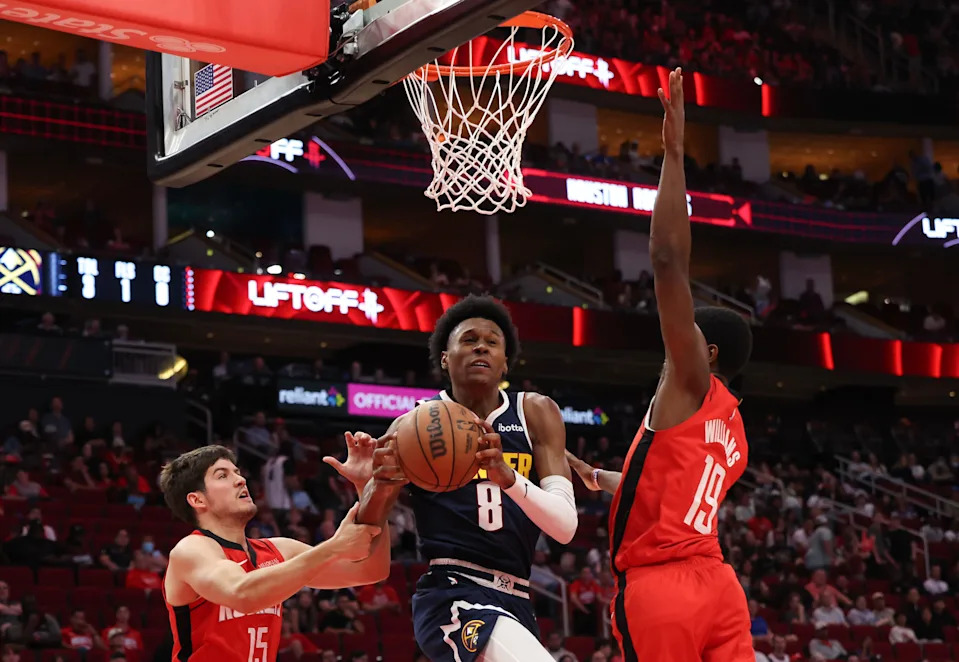 Apr 13, 2025; Houston, Texas, USA; Denver Nuggets forward Peyton Watson (8) splits the defense of Houston Rockets guard Reed Sheppard (15) and Houston Rockets guard (19) in the second half at Toyota Center. Mandatory Credit: Thomas Shea-Imagn Images