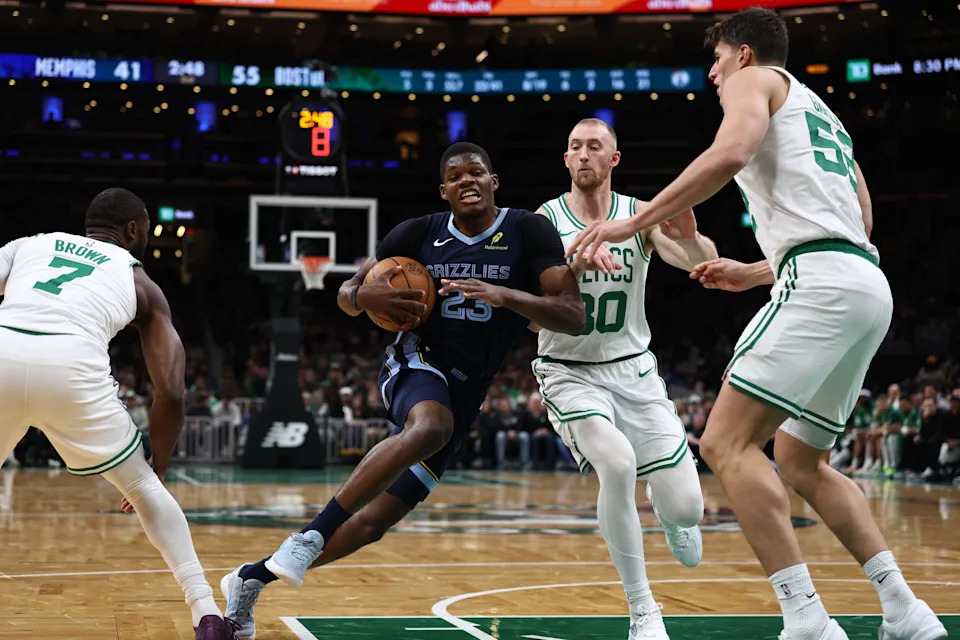 Nov 12, 2025; Boston, Massachusetts, USA; Memphis Grizzlies forward Cedric Coward (23) drives between Boston Celtics guard Jaylen Brown (7), forward Sam Hauser (30) and center Luka Garza (52) during the second quarter at TD Garden. Mandatory Credit: Winslow Townson-Imagn Images