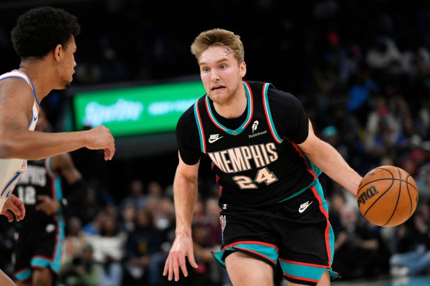 Memphis Grizzlies guard Cam Spencer (24) handles the ball against Oklahoma City Thunder forward Ousmane Dieng, left, in the first half of an NBA basketball game Sunday, Nov. 9, 2025, in Memphis, Tenn. (AP Photo/Brandon Dill)
