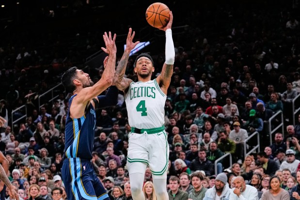 Celtics guard Anfernee Simons (4) shoots against Memphis Grizzlies forward Santi Aldama during the first half of an NBA game Wednesday in Boston. (AP Photo/Charles Krupa)