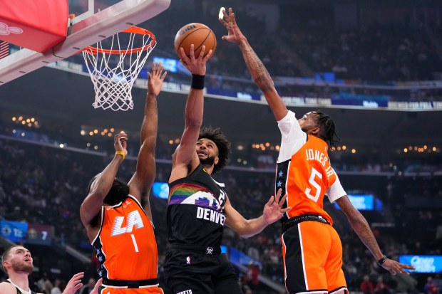 Denver Nuggets guard Jamal Murray, center, shoots as Clippers guard...