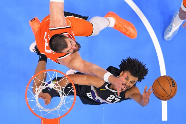 Denver Nuggets guard Jamal Murray, right, shoots as Clippers center...