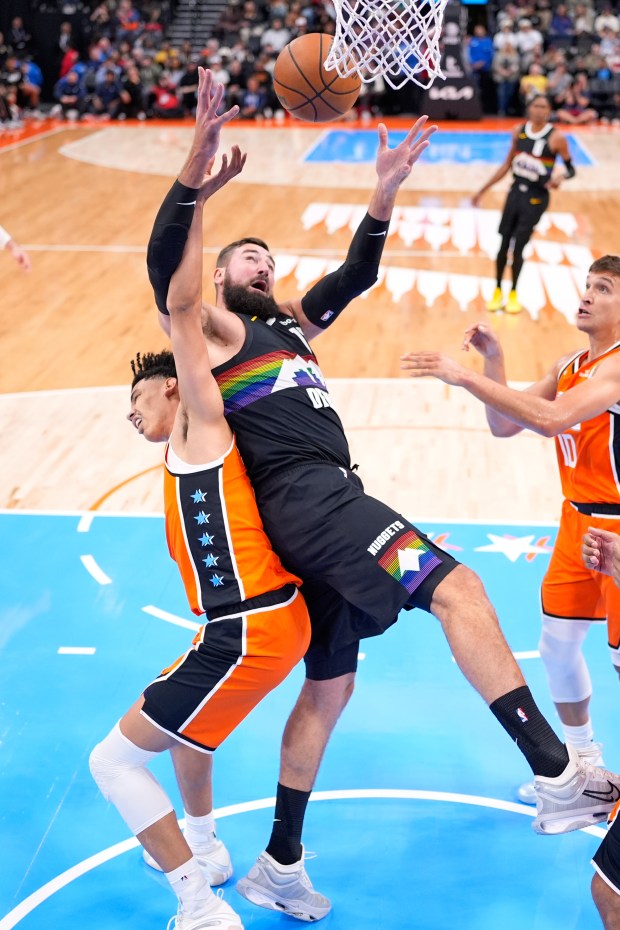 Clippers guard Kobe Sanders, left, and Denver Nuggets center Jonas...