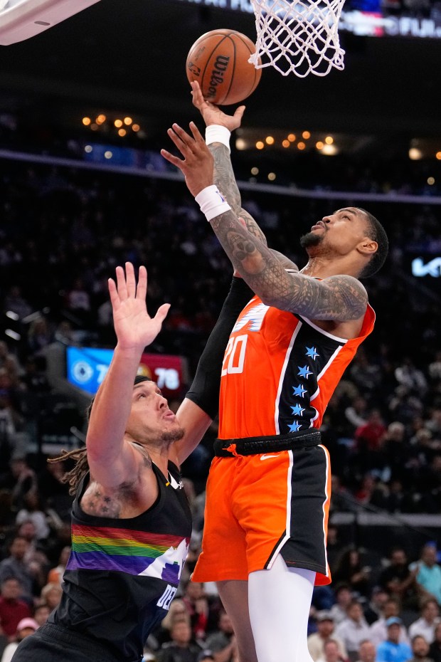 Clippers forward John Collins, right, shoots as Denver Nuggets forward...