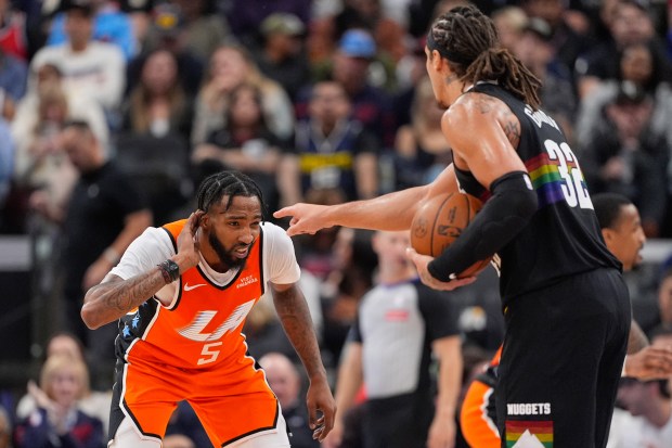 Clippers forward Derrick Jones Jr., rubs his ear while guarding...