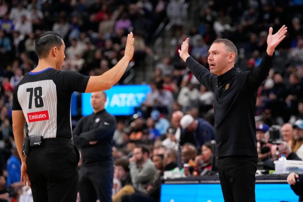 Denver Nuggets head coach David Adelman, right, questions a call...